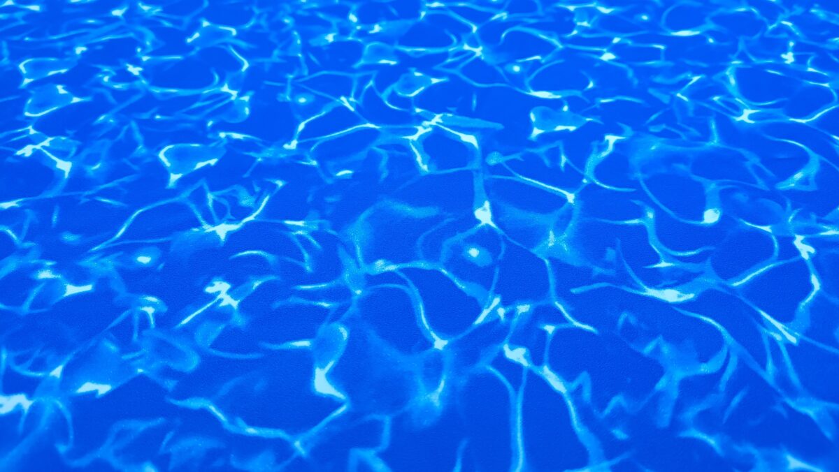 Detailní pohled na prémiovou bazénovou fólii Galaxy Aqua s třpytivým leskem a vzorem Waves. Třpytivý odlesk podtrhuje luxusní vzhled vody.